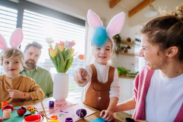 istock Happy family with little kids decorating easter eggs. 1464781821