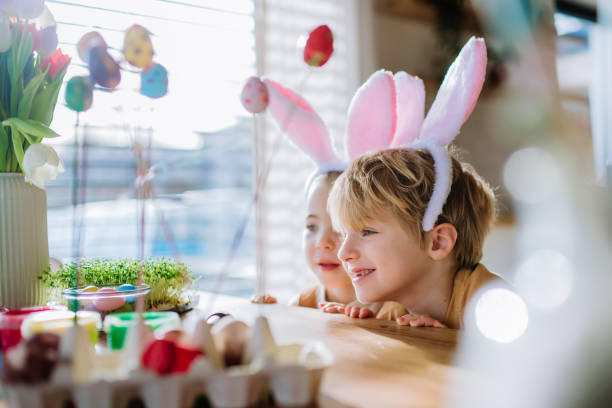 istock Happy siblings looking at growing plants after decorating easter eggs. 1464781876