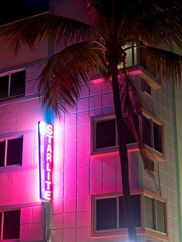 Miami Beach, FL - USA, February 1, 2023. The neon Starlite hotel sign illuminates the building facade on Ocean drive Miami Beach. An nighttime architectural detail of art deco.