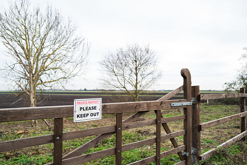 Shallow focus of a a Private Property sign attached to a wooden gate. Used for access to a horse paddock in a rural location.