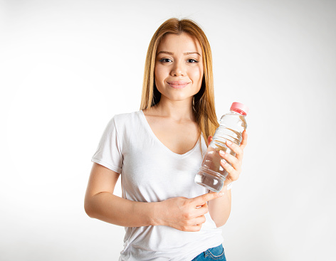 Smiling woman holding water bottle.