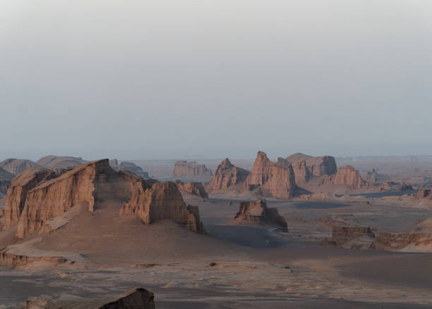 istock Peaceful view of the beautiful Dasht-e Lut Desert and its rock formations (Kaluts) at sunset, Kerman Province, Iran 1464786798