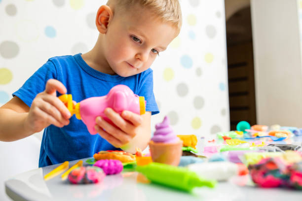 istock Cute children sitting at the table and plays with playdough 1464787044