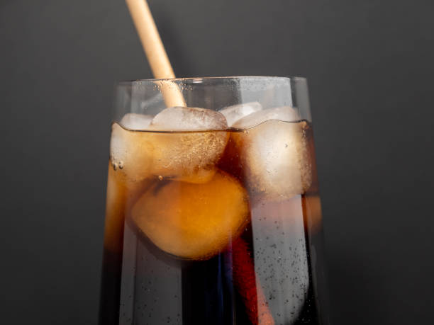istock Glass of cola with ice on a black background. 1464787051
