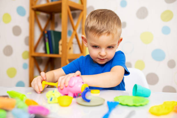 istock Cute children sitting at the table and plays with playdough 1464787070