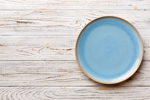 istock Top view of empty blue plate on wooden background. Empty space for your design 1464787180