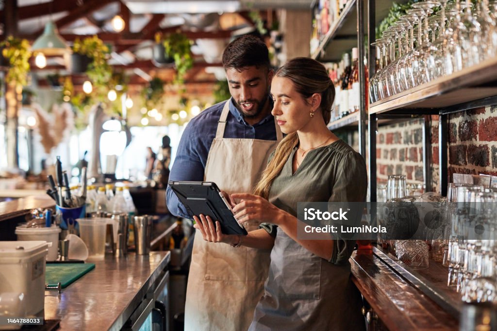 Tablet, bartender or small business people for communication, networking or online order check. Research, planning startup or teamwork for inventory checklist, stock management or social media review Restaurant Stock Photo