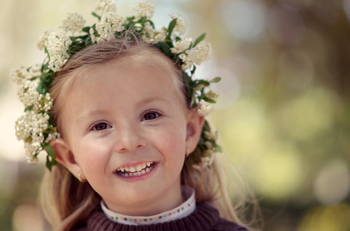 Portrait of little girl with a wreath of flowers