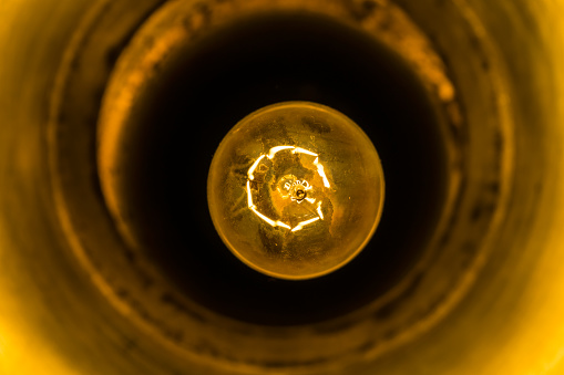 Close up of a fluorescent light bulb in a metal tube. Toned.