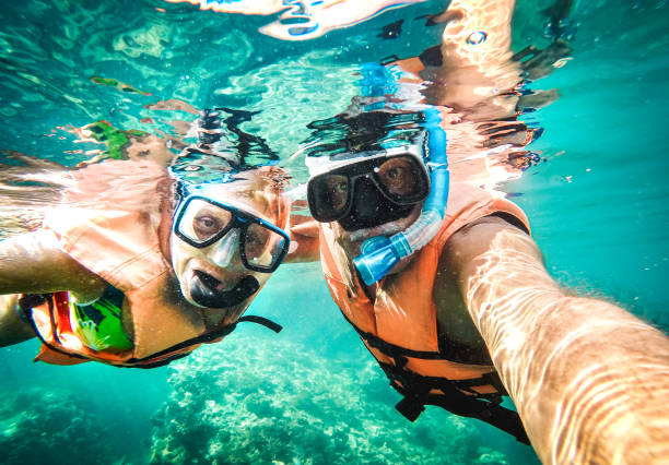istock Active senior couple taking under water selfie in tropical sea excursion with water camera - Boat trip snorkeling in exotic scenario - Retired elderly life style concept on scuba diving - Vivid filter 1464791815