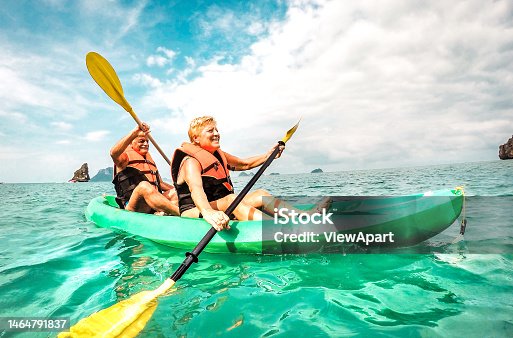 istock Happy retired couple enjoying travel moment paddling on kayak at Angthong marine park in Ko Samui in Thailand - Active elderly concept around world nature wonders - Bright vivid filtered tone 1464791837