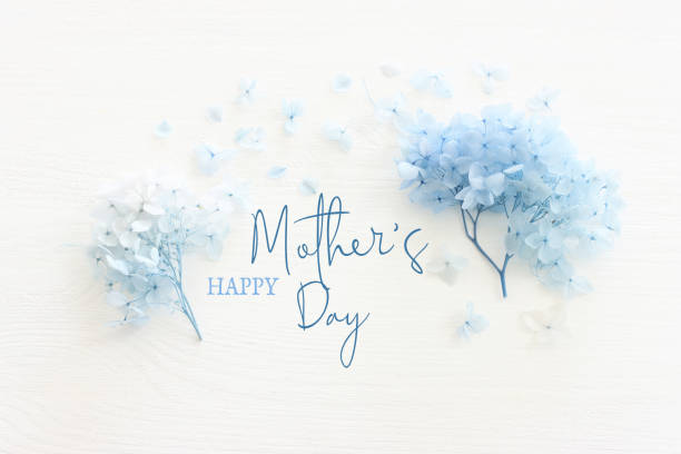 白い木の背景に母の日のコンセプトと青い花