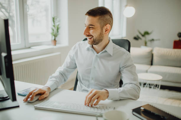 istock Joyful young businessman working on the computer in his office 1464797457