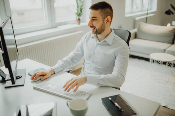 istock High-angle view of a joyful young businessman working on the computer in his office 1464797486