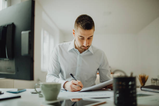 istock Young businessman doing paperwork in his office 1464797539