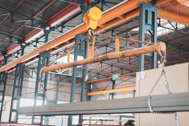 Overhead crane with magnetic grippers lifting steel sheets
