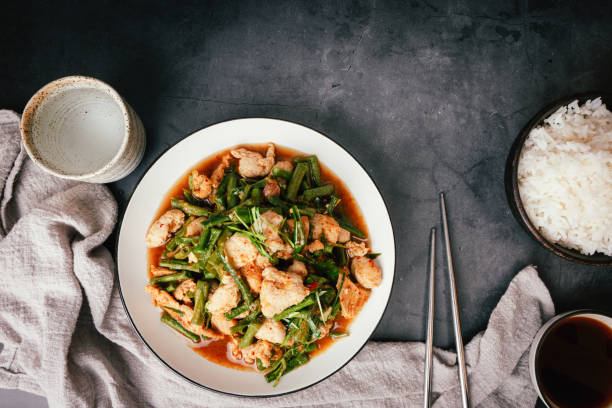 istock Top view,  Stir-fried pork and red hot curry paste with or long bean and Ingredients are oyster sauce, fish sauce, sugar, kaffir lime leaves in the dish Eat with cooked rice. Thai food 1464801075