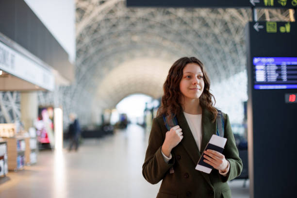 istock Smiling young woman waiting at flight gates for plane boarding 1464801128