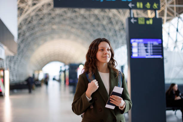 istock Smiling young woman waiting at flight gates for plane boarding 1464801139