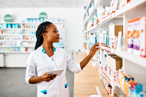 Pharmacy, digital tablet and pharmacist with inventory product software management for retail pills or medicine healthcare. Medical pharmaceutical worker doctor reading label and data erp information