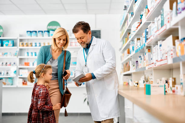 istock Happy mother and daughter using touchpad with their pharmacist in a pharmacy, 1464802634
