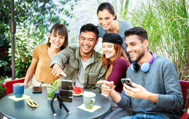 istock Young people sharing content on streaming platform at coworking cafeteria - Youth life style tech concept with happy milenial influencers having fun vlogging live feeds at coffee bar - Bright filter 1464804697
