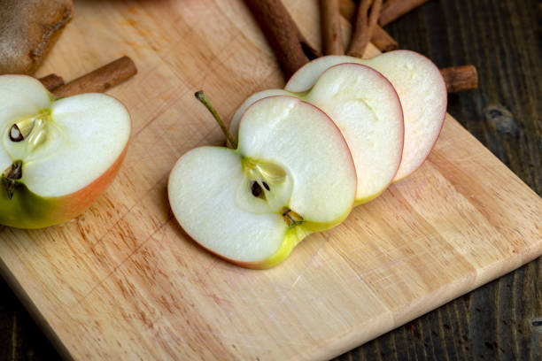 High angle close-up of prepared mixed raw apple pie filling -- sliced apples, lemon juice, cinnamon, nutmeg, allspice, brown sugar, flour.