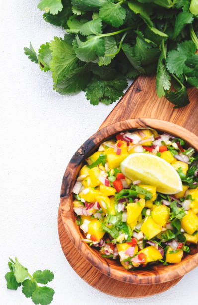 istock Spicy mango salsa sauce with red chili peppers, onion, garlic, lime and cilantro, white table background, top view 1464807000