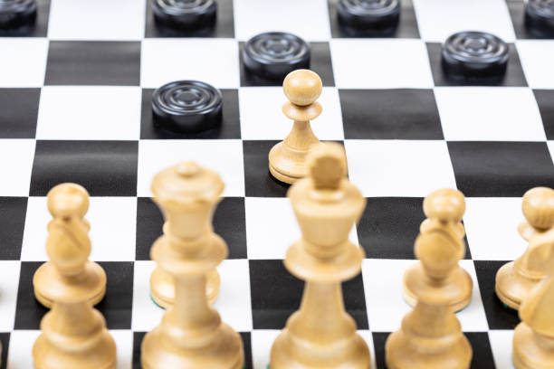istock white pawn and black checkers disc moves closeup 1464815795