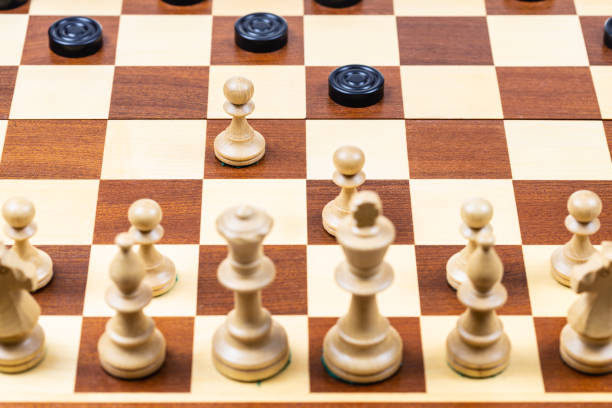 istock white pawns attack black checkers on wood board 1464815933