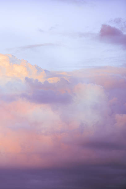 Sky with soft and fluffy pastel lilac pink and blue colored clouds. Sunset background. Nature. sunrise. Instagram toned style. Vertical stock photo