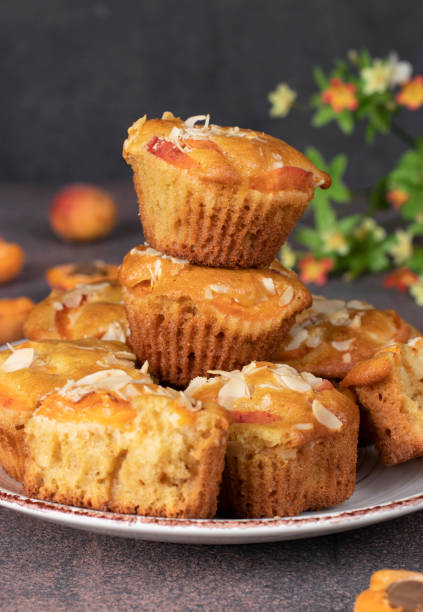 istock Homemade muffins with apricots and almonds on brown background 1464820942