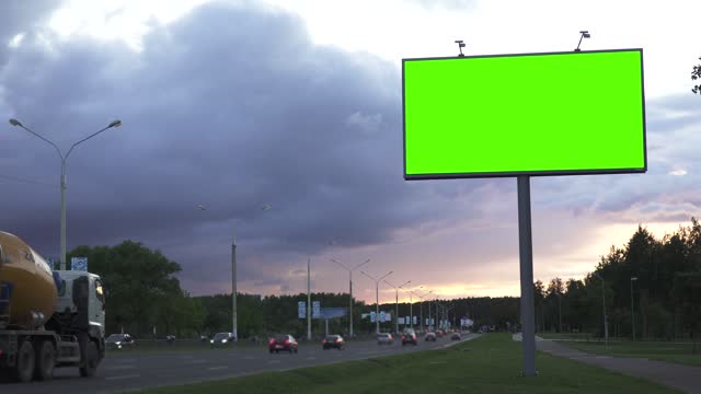 Mock up concept. Green screen billboard on the the highway against the background of the evening sky.