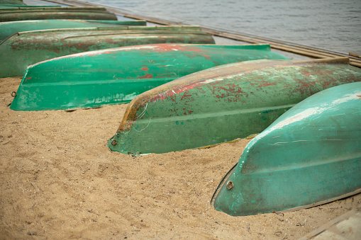 Old boats are overturned on shore. Boat station. Boats are drying up. Water transport.