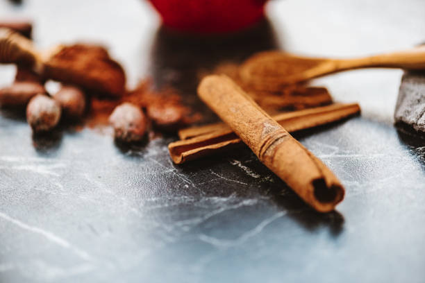 Ground cinnamon with cinnamon sticks and cocoa powder shot on black marble