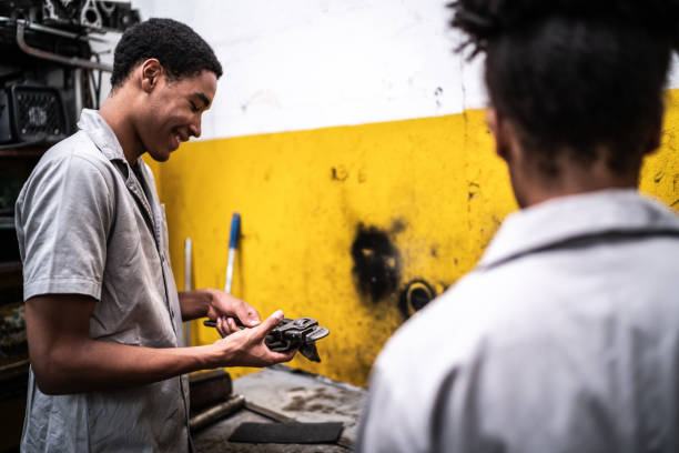 Auto mechanic man talking with his colleague while work on a repair shop
