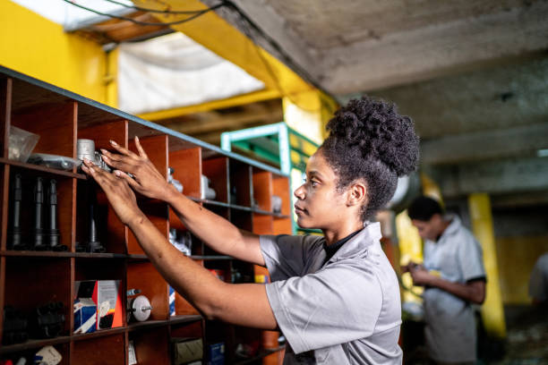 mulher mecânica de automóveis organizando a prateleira em uma oficina de reparos - storage compartment garage warehouse storage room - fotografias e filmes do acervo