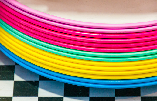 A stack of dinner plates of bright pastel colors  in a shop window