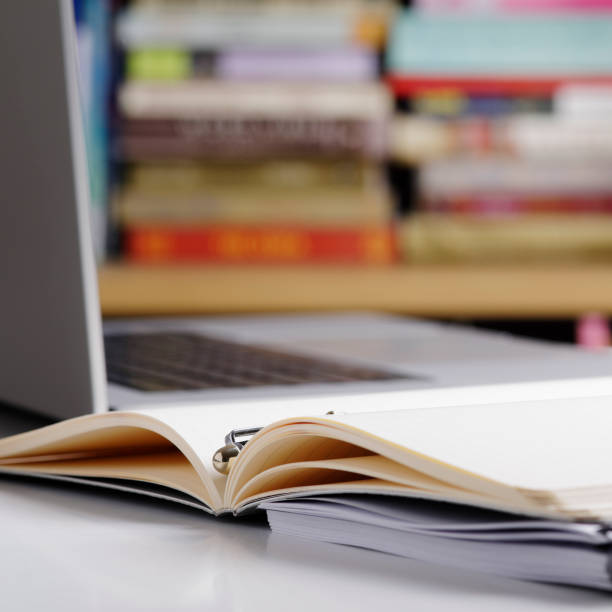 istock Close up of open note pad and  laptop computer at the library 1464841323