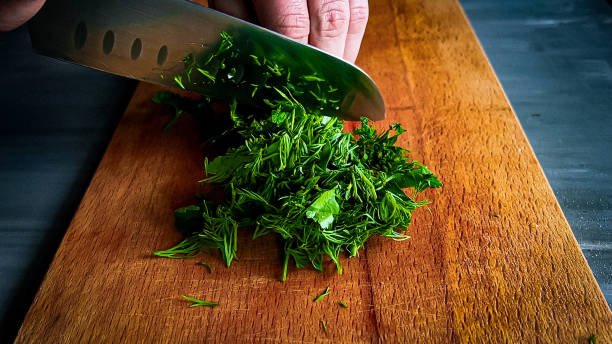 chopped parsley on a cutting board chopped parsley on a cutting board chopped dill stock pictures, royalty-free photos & images