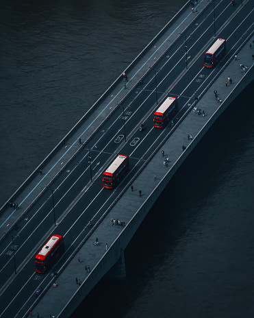 Aerial view of London Bridge and four red colour double-decker buses on traffic in London, England, United Kingdom