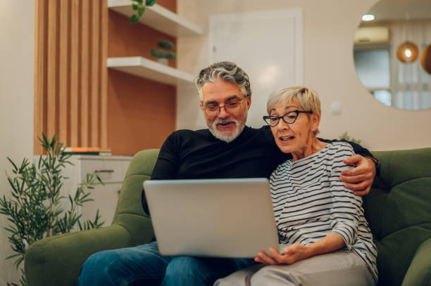 istock Senior couple using laptop while sitting on a couch at home 1464846871