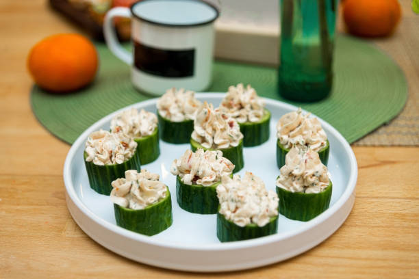Cucumber canape stuffed with crab meat and cream cheese with walnuts on a plate stock photo