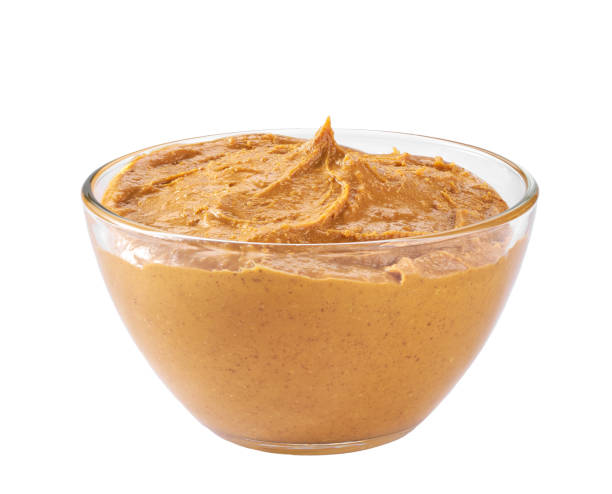 istock Creamy peanut butter in bowl isolated on white background. 1464850498