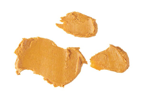 istock smears or splashes of peanut butter isolated on white background, top view. 1464850507