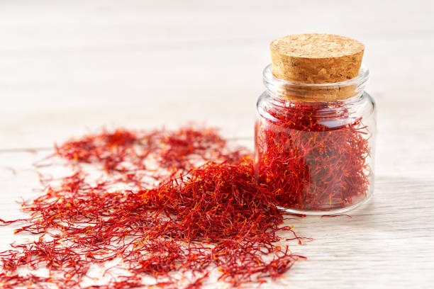 istock Dried saffron spices in a bottle on a wooden table, selective focus. 1464850516