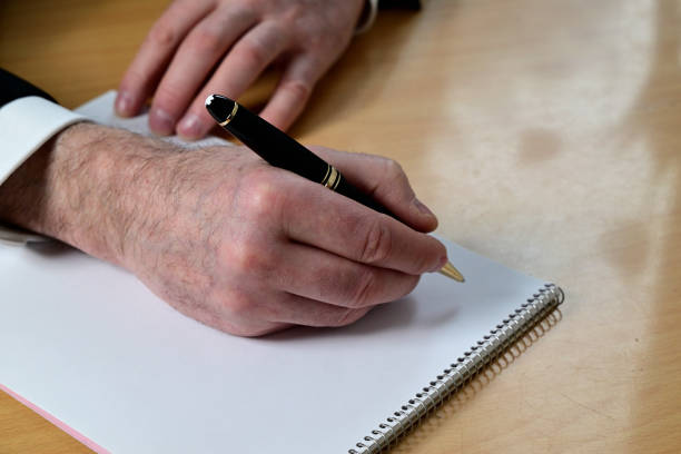 istock hand of a man with ballpoint pen 1464853148