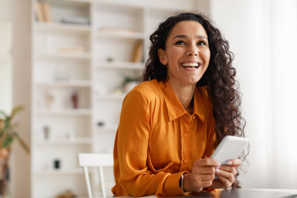 istock Happy Middle Eastern Lady Using Smartphone Sitting At Desk Indoor 1464865596