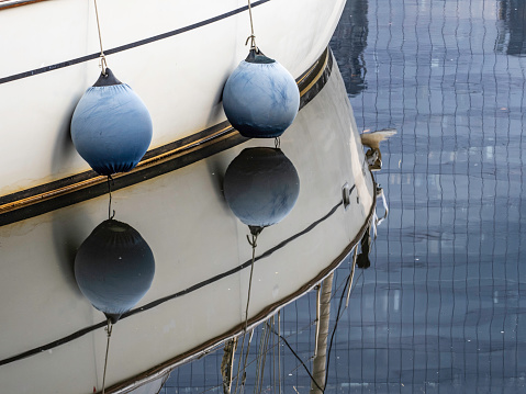 Yacht sailing in an open sea. Close-up view of side of the boat. Clear sky after the rain, waves and water splashes. High quality photo