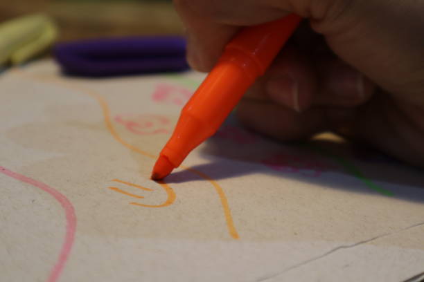istock Person Drawing a Happy Expression on Paper with Colored Pen 1464868945
